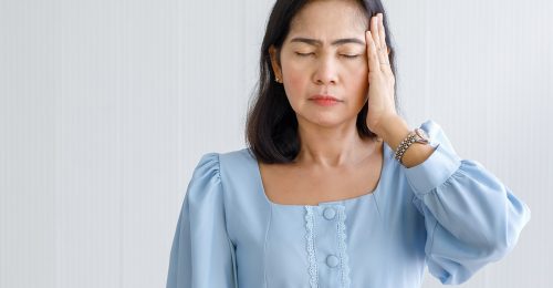 Middle age Asian woman feeling pain and suffer from sudden headache and brain stroke attack and hold her head with suffer face. Concept of brain and head problem.